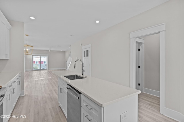 kitchen with appliances with stainless steel finishes, light hardwood / wood-style flooring, sink, white cabinetry, and a kitchen island