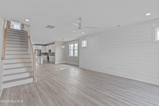 unfurnished living room featuring ceiling fan and light wood-type flooring