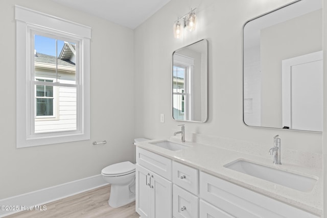 bathroom with vanity, toilet, and hardwood / wood-style floors