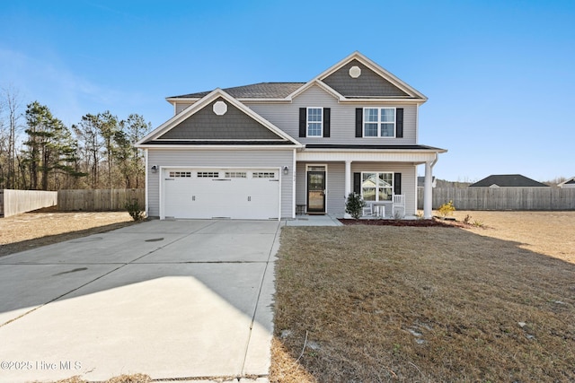 view of front facade with a front lawn, fence, a porch, and concrete driveway