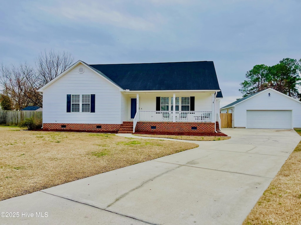 single story home featuring a garage, an outdoor structure, a porch, and a front yard