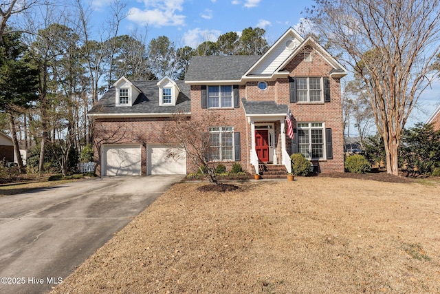 view of front of house featuring driveway, brick siding, a front lawn, and an attached garage