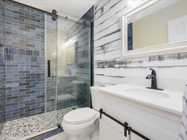 bathroom with vanity, a shower with door, and toilet