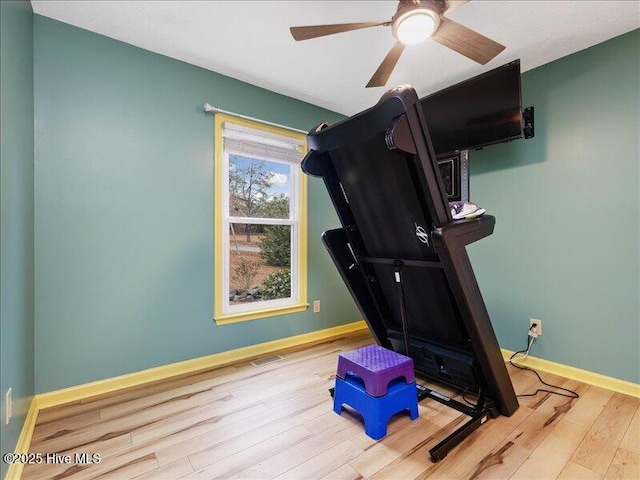 exercise room featuring ceiling fan and light wood-type flooring