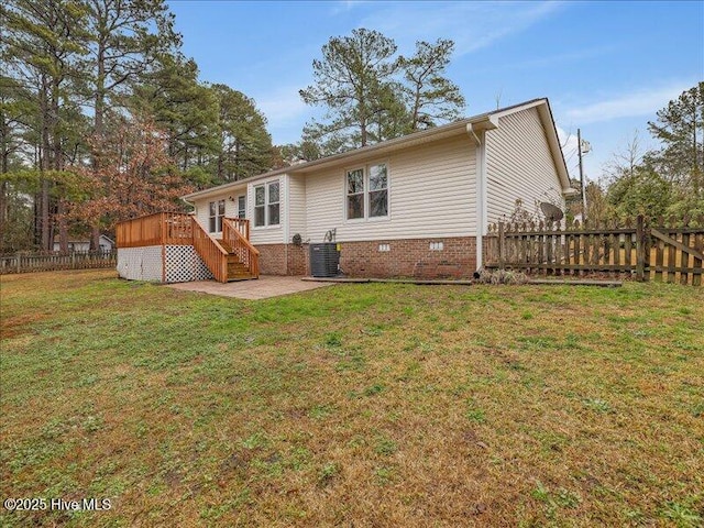 back of property featuring a deck, central AC unit, and a lawn