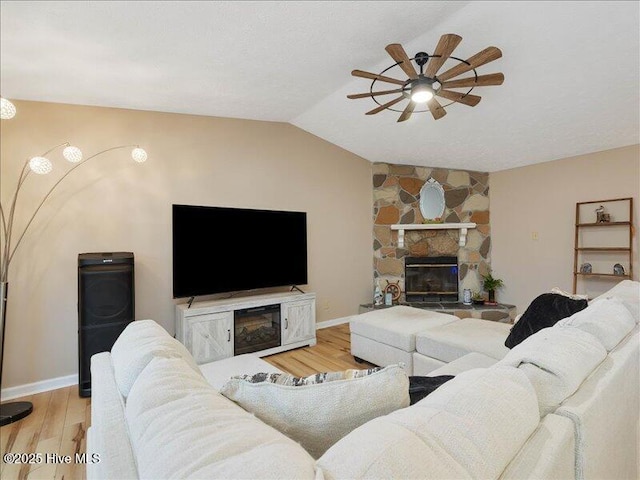 living room with lofted ceiling, a fireplace, wood-type flooring, and ceiling fan