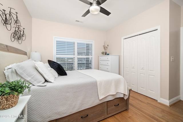 bedroom with a closet, visible vents, ceiling fan, light wood-type flooring, and baseboards