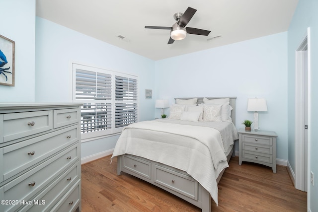 bedroom featuring baseboards, visible vents, and light wood finished floors