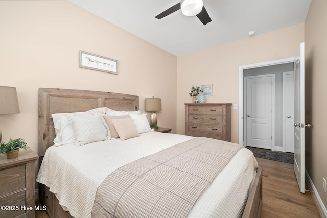 bedroom with a ceiling fan, baseboards, and wood finished floors