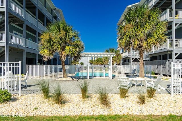 community pool featuring a patio area, fence, and a pergola