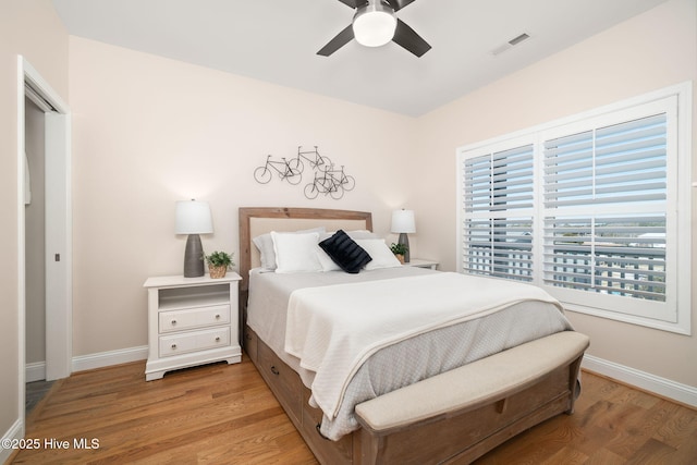 bedroom featuring ceiling fan, wood finished floors, visible vents, and baseboards