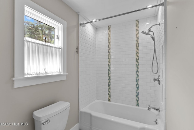 bathroom featuring tiled shower / bath combo and toilet