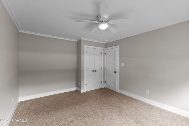 unfurnished bedroom featuring ceiling fan, ornamental molding, a closet, and carpet