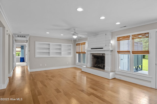 unfurnished living room with ornamental molding, a fireplace, light hardwood / wood-style floors, and ceiling fan