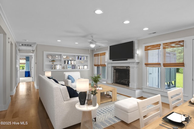 living room with crown molding, ceiling fan, and hardwood / wood-style floors