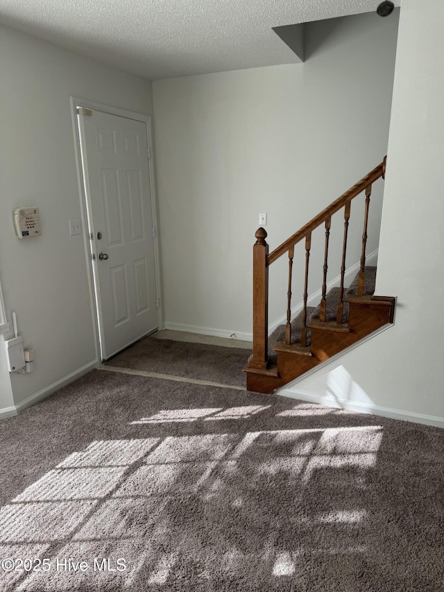 entryway featuring carpet floors and a textured ceiling