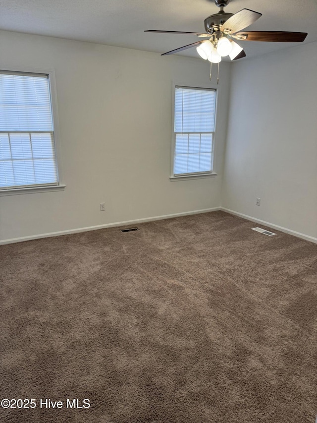 carpeted spare room featuring ceiling fan and a wealth of natural light