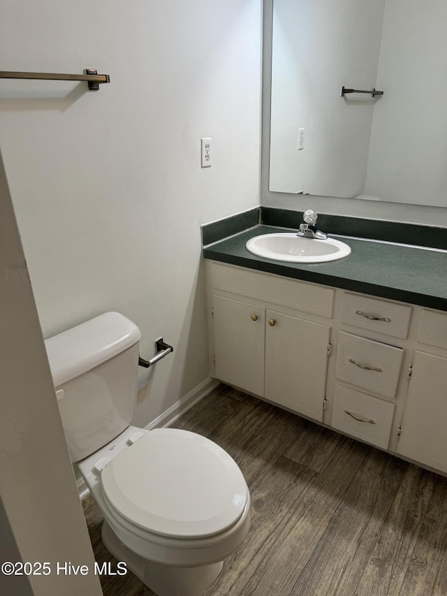 bathroom featuring vanity, hardwood / wood-style floors, and toilet