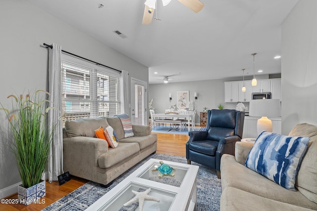 living room featuring hardwood / wood-style floors and ceiling fan