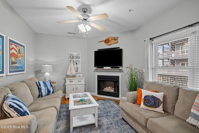 living room with ceiling fan and wood-type flooring