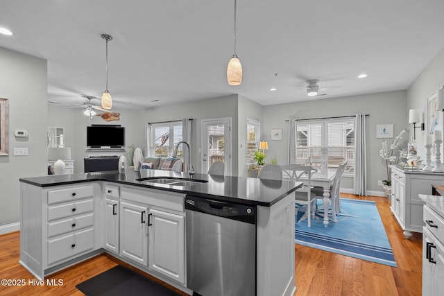 kitchen featuring light hardwood / wood-style flooring, sink, dishwasher, white cabinets, and hanging light fixtures