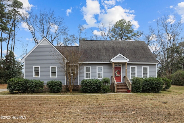 view of front of house featuring entry steps, a shingled roof, and a front lawn