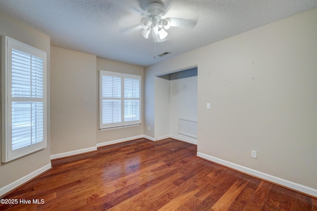 spare room with ceiling fan, dark hardwood / wood-style floors, and a textured ceiling