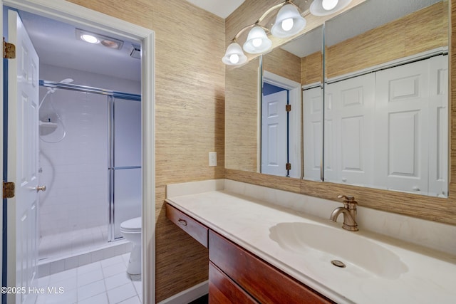 bathroom featuring tile patterned flooring, vanity, toilet, and a shower with shower door