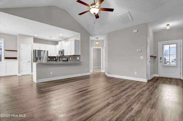 unfurnished living room with high vaulted ceiling, dark hardwood / wood-style floors, sink, and ceiling fan