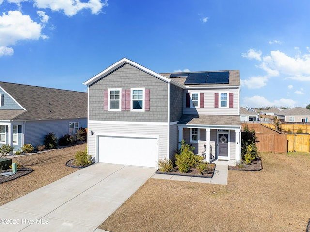 front of property featuring a garage, solar panels, a porch, and a front yard