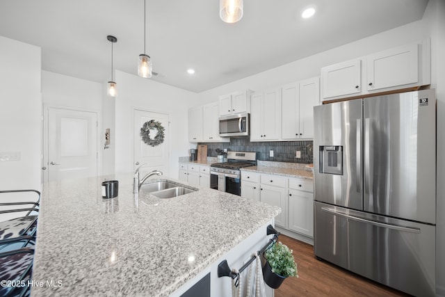 kitchen with white cabinetry, appliances with stainless steel finishes, sink, and hanging light fixtures