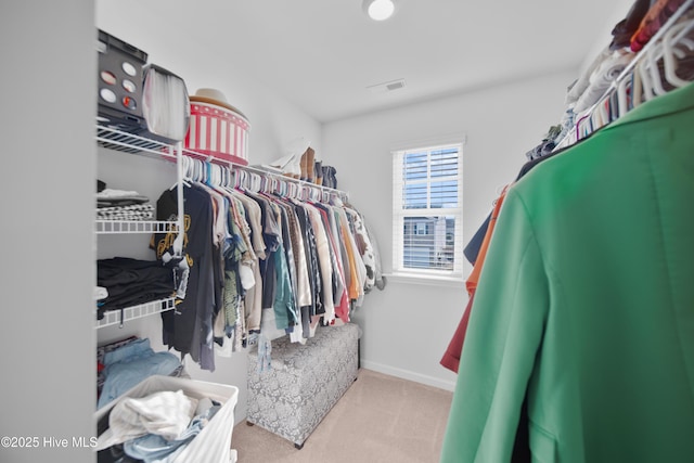 walk in closet featuring light carpet