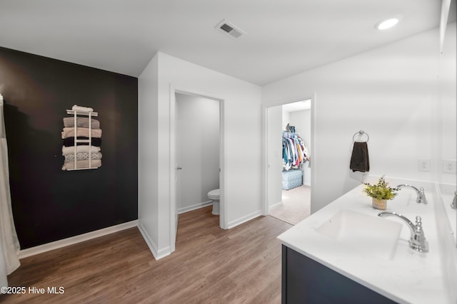 bathroom with wood-type flooring, vanity, and toilet