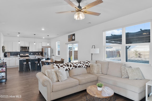 living room featuring ceiling fan and dark hardwood / wood-style floors