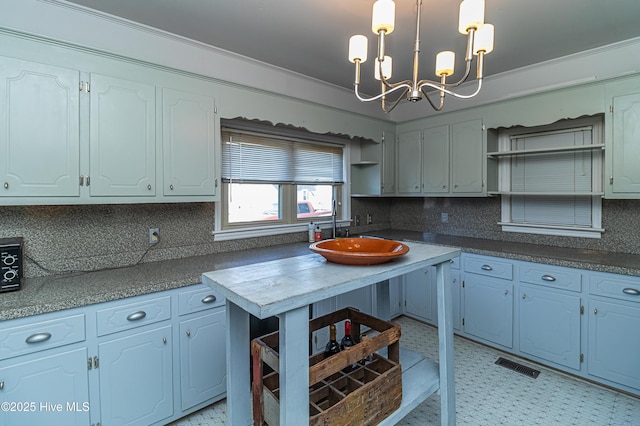 kitchen with a notable chandelier, decorative light fixtures, tasteful backsplash, and white cabinetry