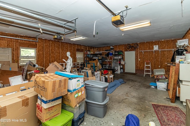 garage with a garage door opener and wooden walls