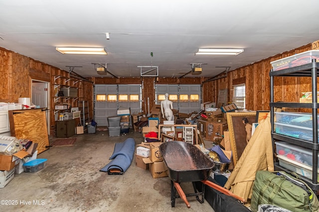 garage featuring a garage door opener and wood walls