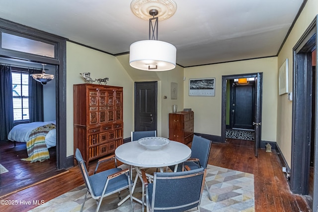 dining space featuring ornamental molding and dark hardwood / wood-style flooring