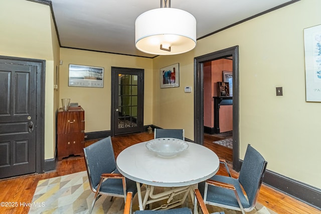 dining space featuring ornamental molding and hardwood / wood-style floors