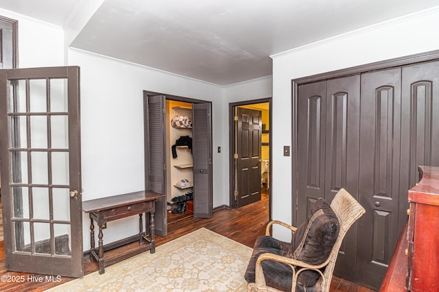 sitting room featuring ornamental molding and dark hardwood / wood-style floors