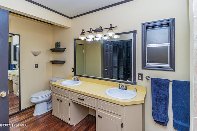 bathroom featuring toilet, hardwood / wood-style flooring, vanity, and ornamental molding