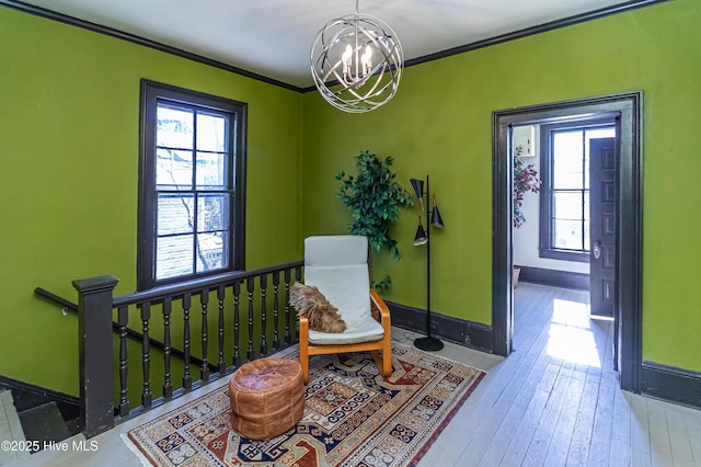 sitting room featuring a notable chandelier, ornamental molding, and hardwood / wood-style floors