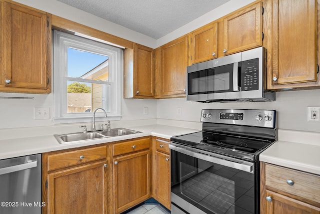 kitchen featuring stainless steel appliances, a sink, and light countertops