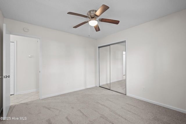 unfurnished bedroom with carpet floors, a ceiling fan, baseboards, and a closet