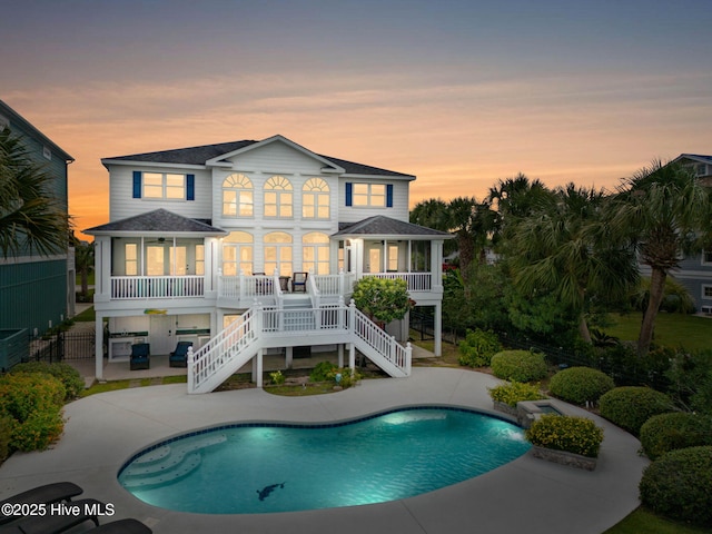 57 Craven St, Ocean Isle Beach, NC 28469 - back of house featuring a patio, stairs, roof with shingles, an outdoor pool, and covered porch