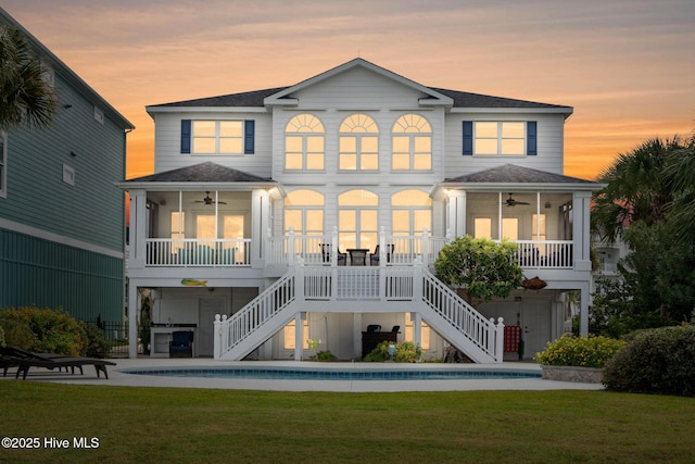 57 Craven St, Ocean Isle Beach, NC 28469 - back of house featuring a ceiling fan, stairway, and a yard