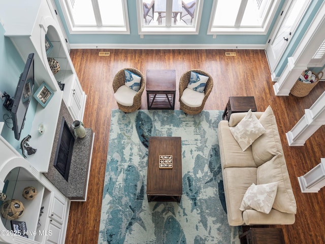 57 Craven St, Ocean Isle Beach, NC 28469 - living area featuring plenty of natural light, wood finished floors, and a fireplace with raised hearth