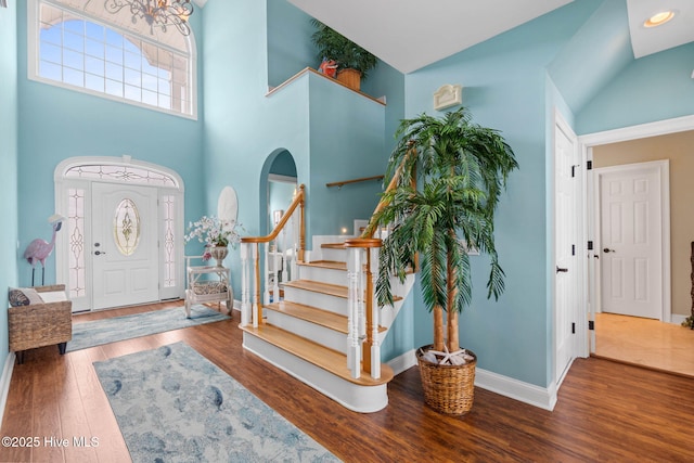 57 Craven St, Ocean Isle Beach, NC 28469 - entryway with wood finished floors, a high ceiling, stairway, and arched walkways