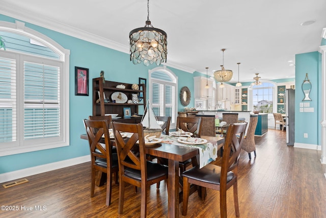 57 Craven St, Ocean Isle Beach, NC 28469 - dining space featuring a chandelier, dark wood-style floors, and ornamental molding