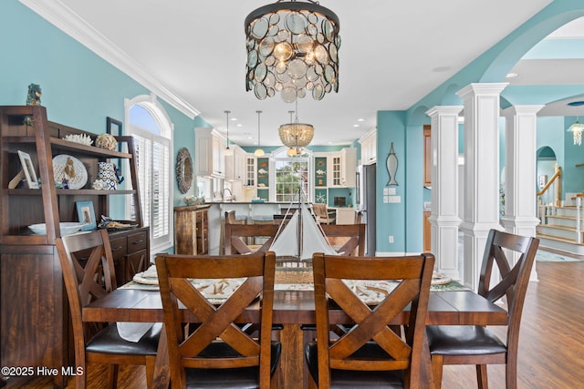 57 Craven St, Ocean Isle Beach, NC 28469 - dining room with arched walkways, a chandelier, wood finished floors, ornamental molding, and recessed lighting